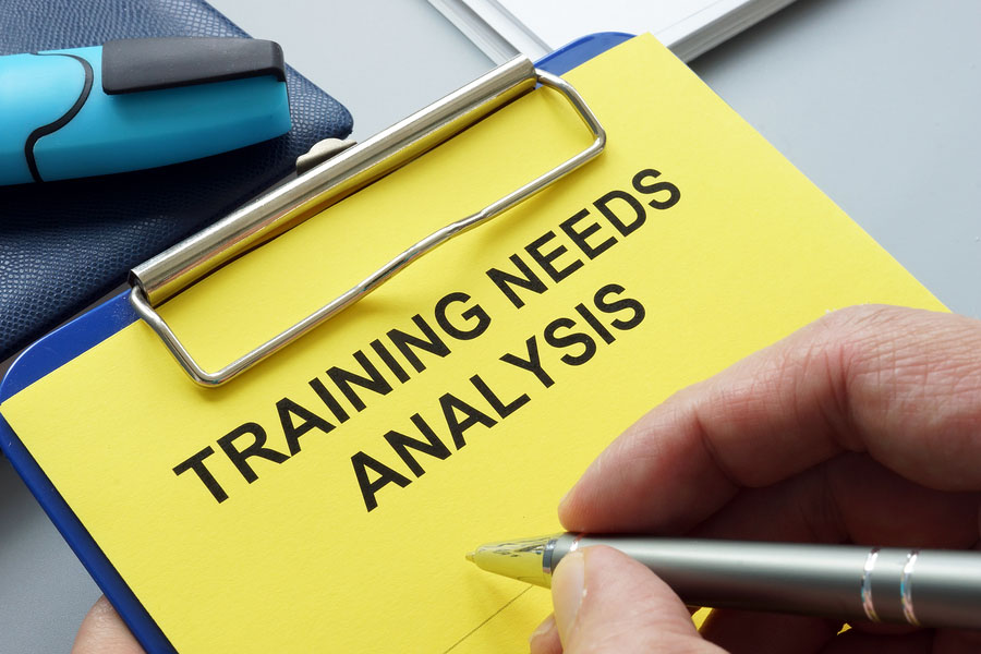 Man Filling In Training Needs Analysis Documents.