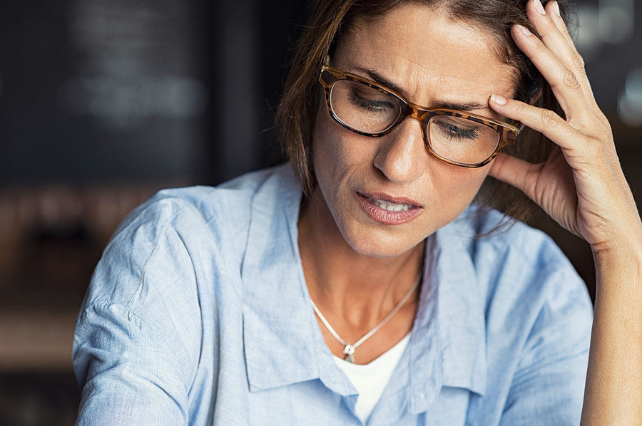 Portrait of stressed mature woman with hand on head looking down